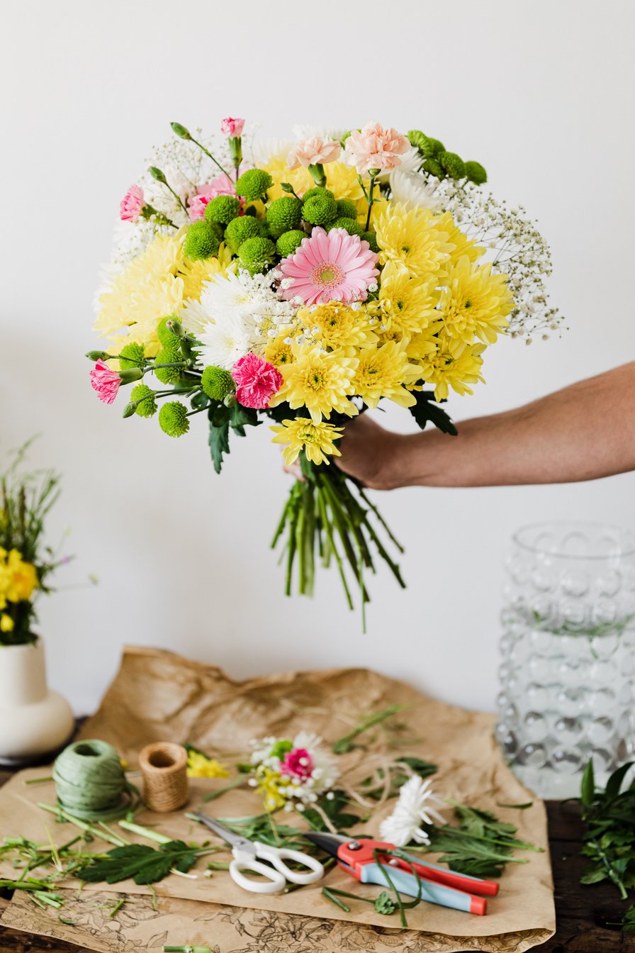 Anonymous florist arranging bouquet in flower shop